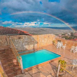 a rainbow over a house with a swimming pool at Hotel Montanhas de Minas in Diamantina