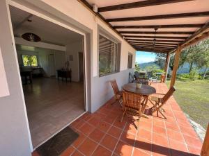 eine Veranda mit einem Tisch und Stühlen auf einer Terrasse in der Unterkunft 972B-Coin de verdure au pied de la Montagne Pelée in Le Morne Rouge