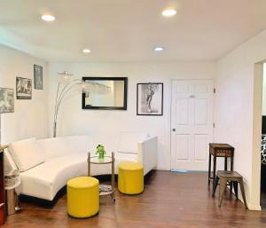a living room with a white couch and yellow stools at Villa de Las Vegas in Los Angeles