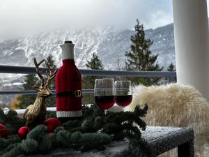 two glasses of red wine sitting on a table with christmas decorations at Ferienwohnungen Tivoli in Bad Reichenhall