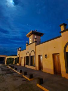 un edificio con una fila de bancos delante de él en Museo Posada Benelli en San Rafael