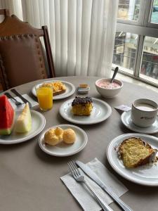 a table with plates of food on top of it at Oscar Palace Hotel - Centro de Tubarão in Tubarão +25 photos
