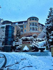 ein Gebäude mit Schnee auf dem Boden davor in der Unterkunft Ferienwohnungen Tivoli in Bad Reichenhall