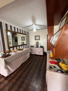 una habitación con dos mesas con plátanos. en Oscar Palace Hotel - SOB NOVA GESTÃO, en Tubarão