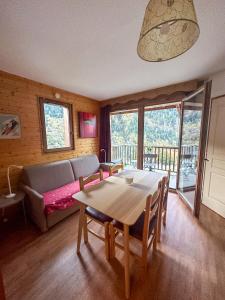 ein Wohnzimmer mit einem Tisch und einem Sofa in der Unterkunft CozyLoge, Orelle & Les 3 vallées in Orelle