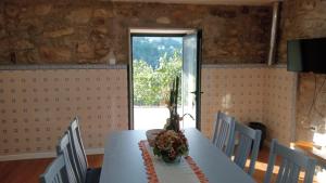 ein Esszimmer mit einem Tisch und einem Fenster in der Unterkunft Private Pool Deep Nature River Sounds Villa in Labruja