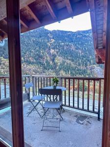 una mesa y sillas en un balcón con vistas en CozyLoge, Orelle & Les 3 vallées en Orelle