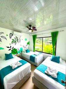 a bedroom with two beds and a window at Oso Perezoso Pool Villa in Puerto Viejo