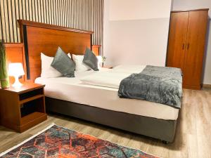 a bedroom with a large bed with a wooden headboard at City Hotel West in Frankfurt