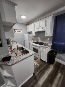 uma pequena cozinha com armários brancos e um lavatório em Blue Shark *G15* @ Montrose Private 1BR King Apartment em Houston