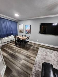 Blue Shark *G15* @ Montrose Private 1BR King Apartment في هيوستن: غرفة طعام مع طاولة وكراسي وتلفزيون بشاشة مسطحة