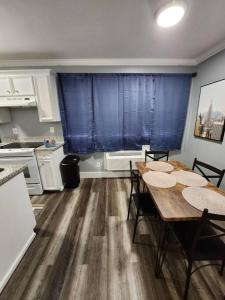 uma cozinha com mesa e cadeiras e cortinas azuis em Blue Shark *G15* @ Montrose Private 1BR King Apartment em Houston