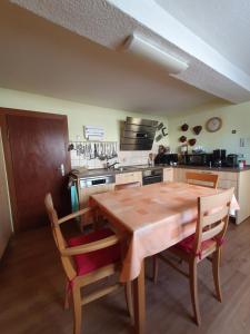 - une cuisine avec une table en bois et des chaises dans l'établissement Ferienhaus in Stockheim, à Stockheim