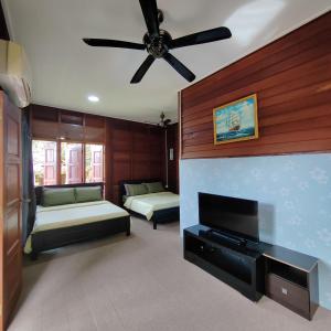 a living room with two beds and a ceiling fan at D'Bukit Forest in Pedas