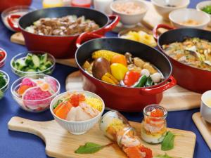 a table with bowls of food and pots of food at Sapporo Granbell Hotel in Sapporo