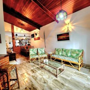 a living room with a couch and chairs and a table at Casa de Praia em Peruibe in Peruíbe