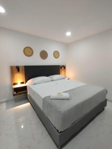 a bedroom with a large white bed with two mirrors on the wall at Zamá Room Hotel in Medellín