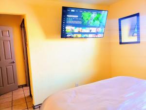 Habitación con cama y TV en la pared. en White Sands Casita en Alamogordo