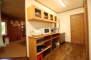 a small kitchen with a microwave on a shelf at Cottage All Resort Service / Vacation STAY 8371 in Inawashiro