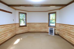 Habitación grande con paredes y ventanas de madera. en Cottage All Resort Service / Vacation STAY 8371, en Inawashiro