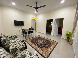 - un salon avec un canapé et une table dans l'établissement BARAKAH HOMESTAY, à Kota Tinggi