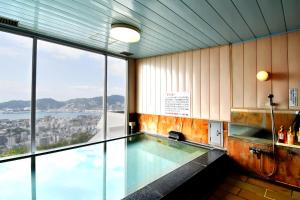 a swimming pool in a building with a large window at Yataro in Nagasaki
