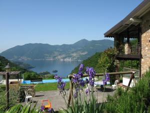 a view of a lake from a house with purple flowers at Chalet della Rota in Marone