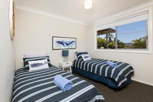 two beds in a room with a window at Lakeview Lodge in Forster