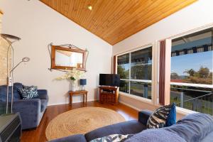 a living room with a blue couch and a tv at Lakeview Lodge in Forster