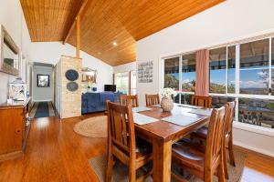 a kitchen and dining room with a wooden table and chairs at Lakeview Lodge in Forster