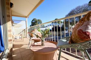 een balkon met 2 stoelen en een vaas met bloemen bij 63a Joondalup Jewel Sleeps 2 1br1bth- SUPERHOG VERIFICATION REQUIRED in Perth