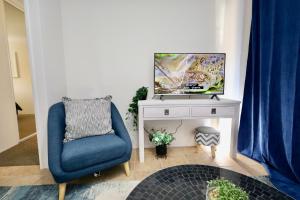 een woonkamer met een blauwe stoel en een tv bij 63a Joondalup Jewel Sleeps 2 1br1bth- SUPERHOG VERIFICATION REQUIRED in Perth