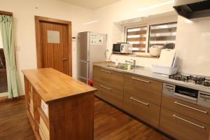 Cottage All Resort Service / Vacation STAY 8410 في Inawashiro: مطبخ مع أجهزة ستانلس ستيل ودواليب خشبية