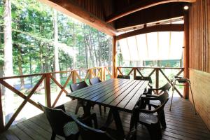 einen Holztisch und Stühle auf dem Deck einer Hütte in der Unterkunft Cottage All Resort Service / Vacation STAY 8410 in Inawashiro