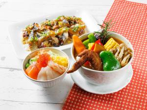 un plato de comida con diferentes alimentos en una mesa en Susukino Granbell Hotel, en Sapporo