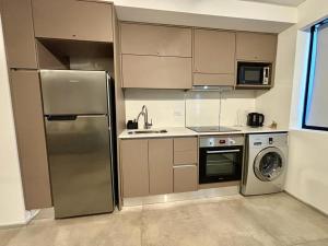 a kitchen with a stainless steel refrigerator and a dishwasher at Playa Grande Apartment Monoambiente in Mar del Plata