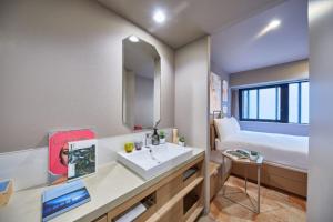 a bathroom with a sink and a bed at lyf Ginza Tokyo in Tokyo
