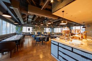 a restaurant with tables and chairs and a bar at Brittany Hotel BGC in Manila