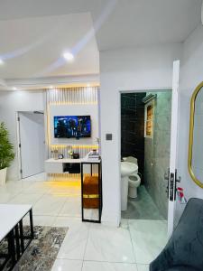 a bathroom with a toilet and a tv on the wall at AMERICANA LUXURY APARTMENT in Lekki +51 photos
