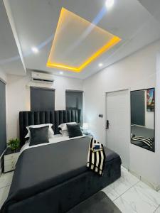 a bedroom with a large bed with a black couch at AMERICANA LUXURY APARTMENT in Lekki