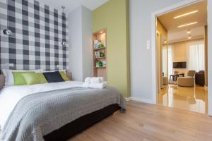 a bedroom with a bed and a living room at Apartament Soleil I in Gdańsk