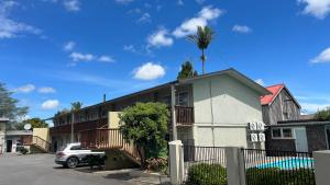 a building with a palm tree on top of it at Aaron Court Motel Whangarei in Whangarei