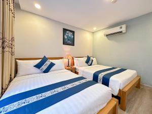 two beds in a hotel room with at LUAN VU Hotel - Bui Vien Walking Street in Ho Chi Minh City