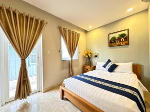 a bedroom with a bed and two windows at LUAN VU Hotel - Bui Vien Walking Street in Ho Chi Minh City