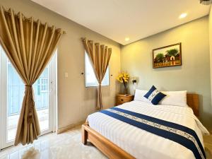 a bedroom with a bed and two windows at LUAN VU Hotel - Bui Vien Walking Street in Ho Chi Minh City