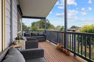 een balkon met banken en een tafel op een huis bij Woolamai Waves Abode in Cape Woolamai