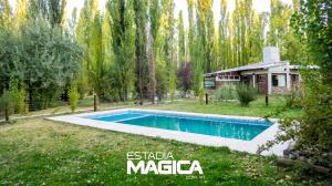 een zwembad in een tuin naast een huis bij Cabañas en Malargue in Malargüe