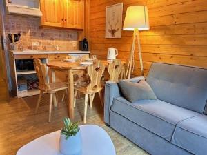 a living room with a blue couch and a table at Appartement Risoul, 1 pièce, 5 personnes - FR-1-330-571 in Risoul