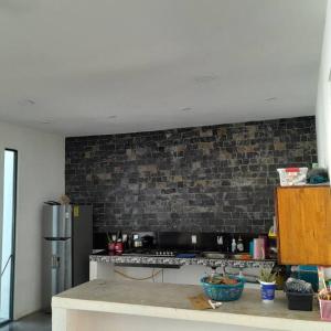 Una cocina con encimera y pared de ladrillo. en Casa Chikatana un lugar familiar y elegante a pasos de la playa Bacocho, en Puerto Escondido 10 fotos más