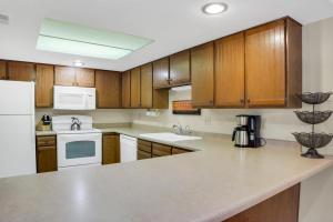 eine Küche mit Holzschränken und weißen Geräten in der Unterkunft PARK STATION 122 condo in Park City
